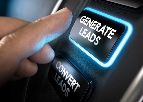 Hand about to press a generate leads button with blue light over black background. Concept of lead management. Composite between a photography and a 3D background. Horizontal image
